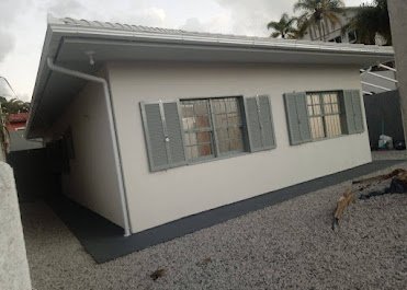 Casa térrea branco-gelo com venezianas cinza